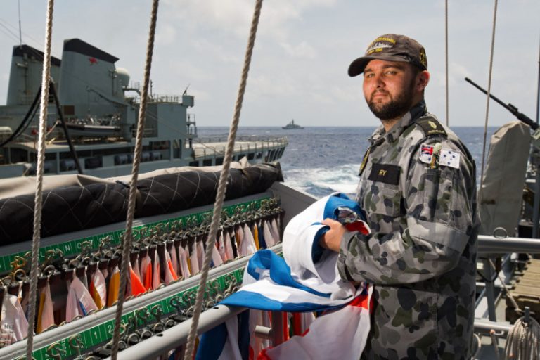 Able Seaman Communication and Information Systems Steven Fry on HMAS Toowoomba's gun direction platform as they conduct a replenishment at sea with HMAS Success during their South East Asia Deployment 2018.